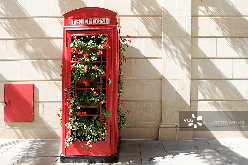 英国巴斯市内的红色电话亭和美丽的红色鲜花图片素材