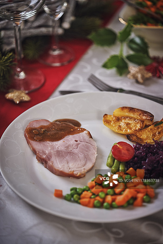 圣诞晚餐：蜜汁火腿、蔬菜、肉馅饼和蛋奶酒橙子甜点图片素材
