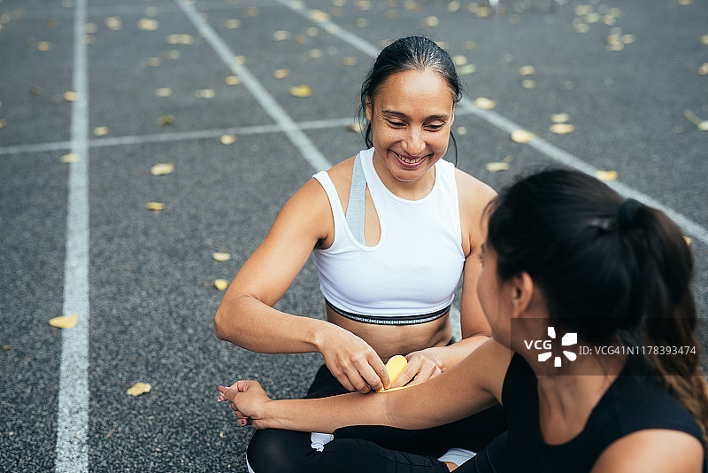 运动后照顾女朋友手臂的女人图片素材