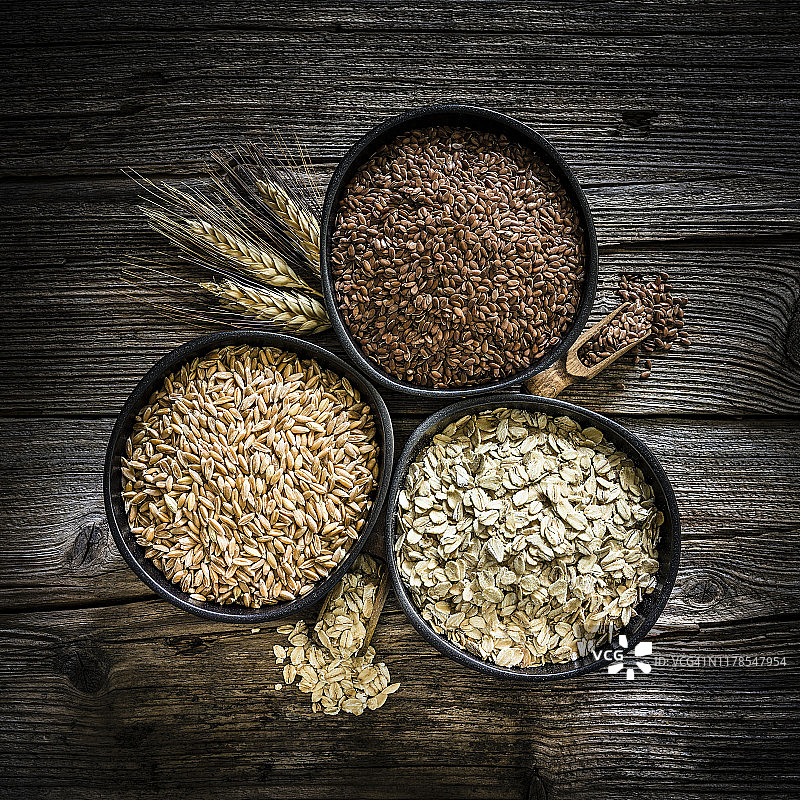 木桌上的斯佩尔特小麦、燕麦片和亚麻籽膳食纤维图片素材