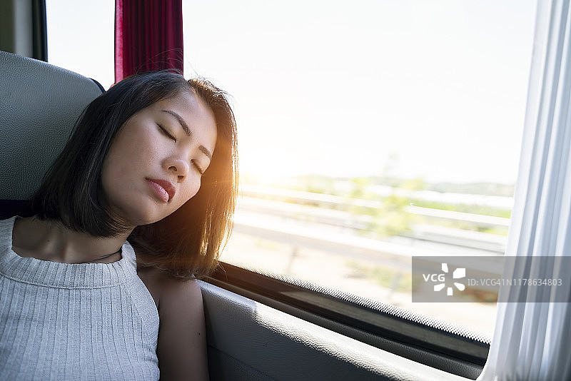 独自旅行的女人在巴士旅行中睡觉图片素材