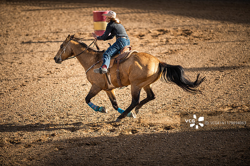 骑马绕桶赛的牛仔女郎图片素材