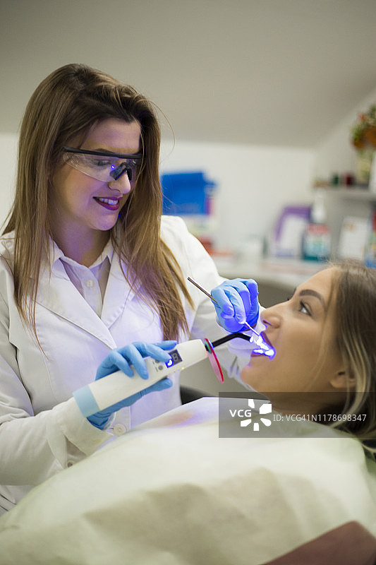在牙医诊所看镜头的微笑美女图片素材