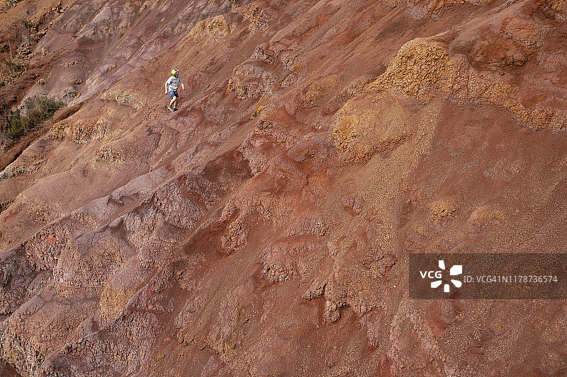 男孩攀爬考艾岛的红色粘土图片素材