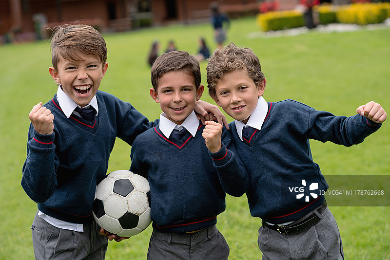 快乐的男孩们在学校踢足球图片素材