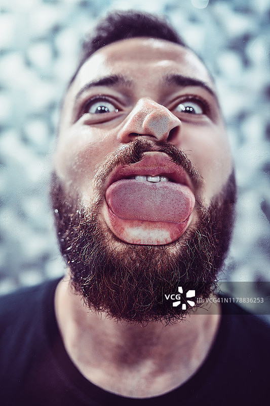 疯狂的男人对着镜子吐舌头图片素材