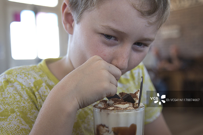 8岁男孩在咖啡馆享用冰巧克力饮品图片素材