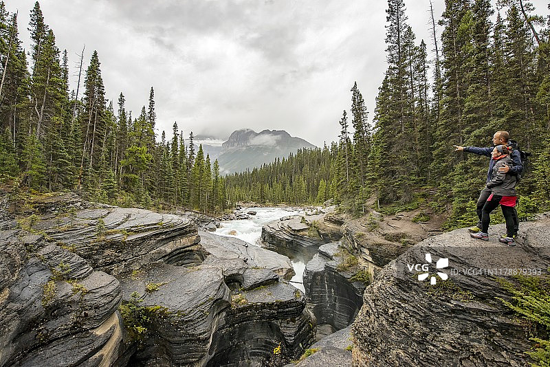 年轻情侣欣赏加拿大班夫国家公园米斯塔亚峡谷图片素材