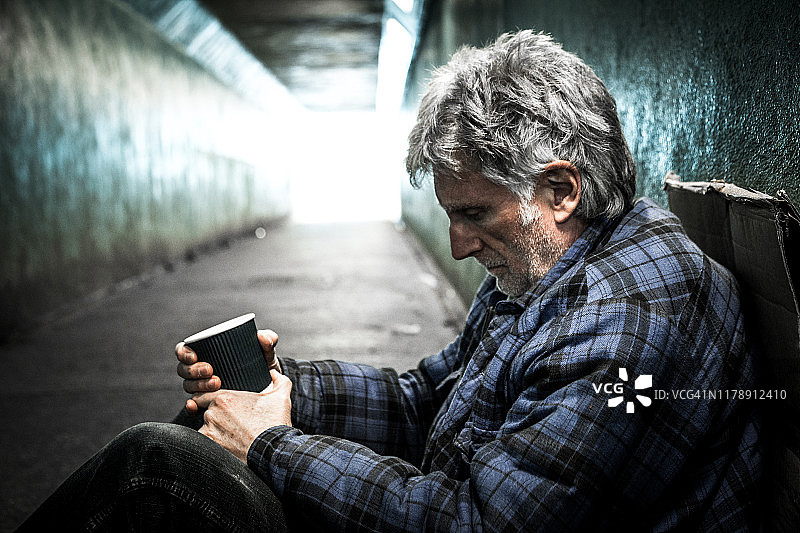 在地铁隧道里乞讨的年长无家可归者图片素材