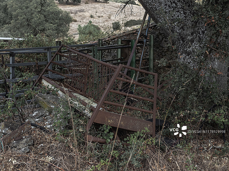 废弃农场里生锈的金属动物喂食器。农村人口减少概念图片素材