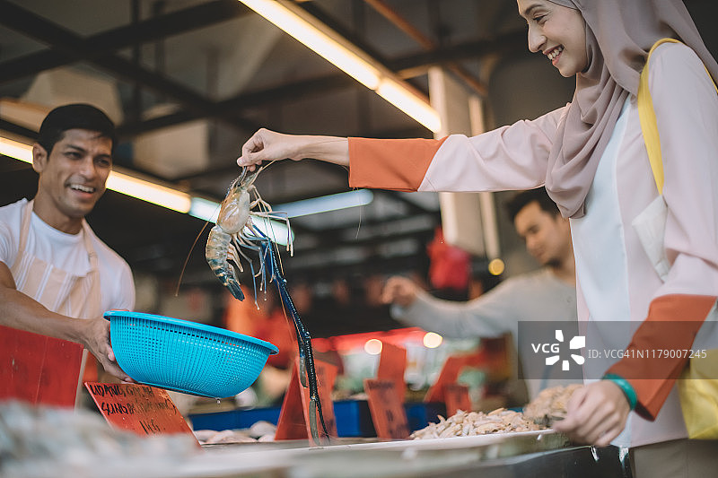 一位马来西亚亚洲女性在菜市场挑选虎虾图片素材