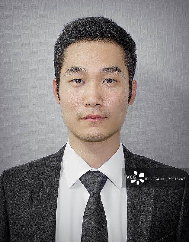 身穿白色衬衫、黑色西装和领带的远东商人图片素材