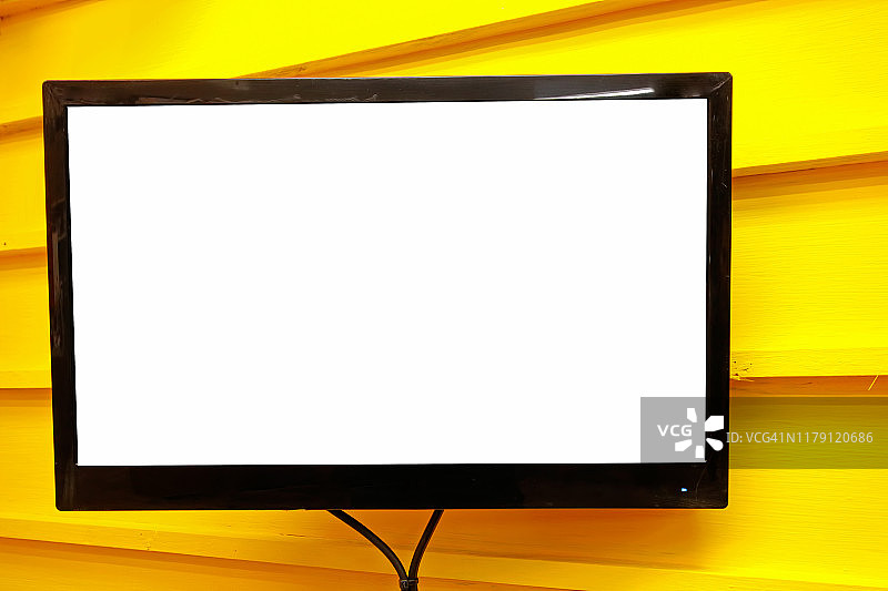 黄色墙壁上的LED电视空白白色屏幕图片素材