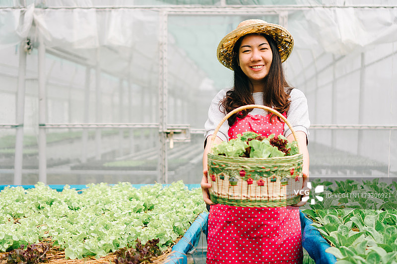 水培蔬菜沙拉农场里微笑的亚洲女农民肖像图片素材
