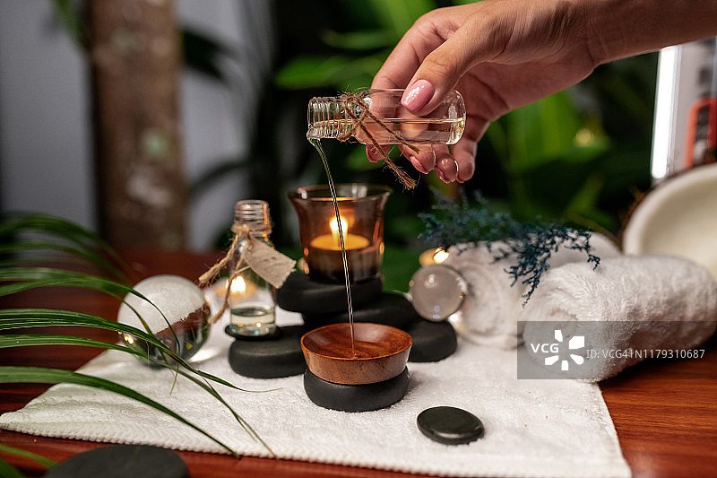 女孩将精油倒入木碗中图片素材