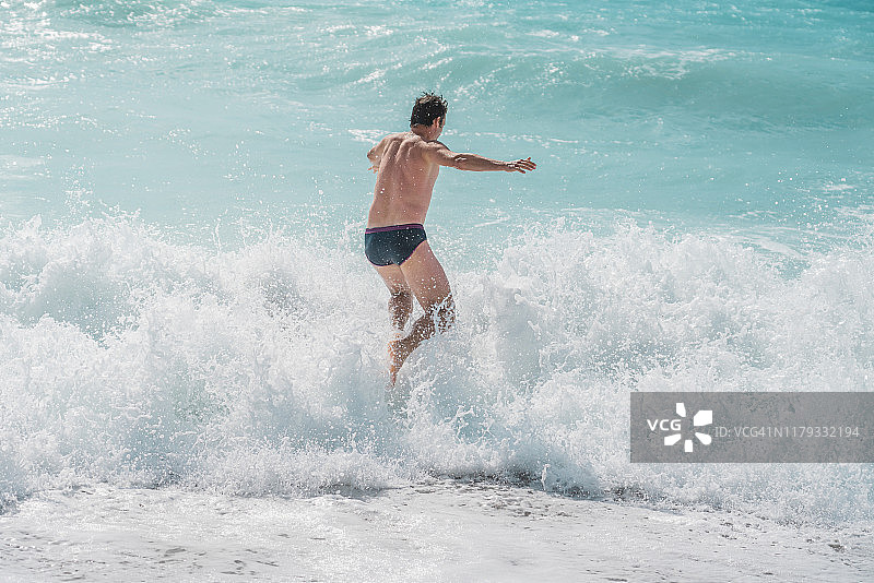 男人在希腊莱夫卡达海边玩耍图片素材
