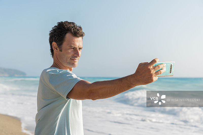 男人在希腊莱夫卡达海边自拍图片素材