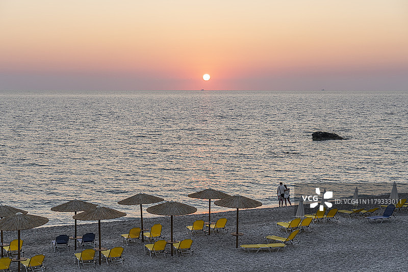 情侣在希腊莱夫卡达岛吉亚洛斯海滩欣赏日落图片素材