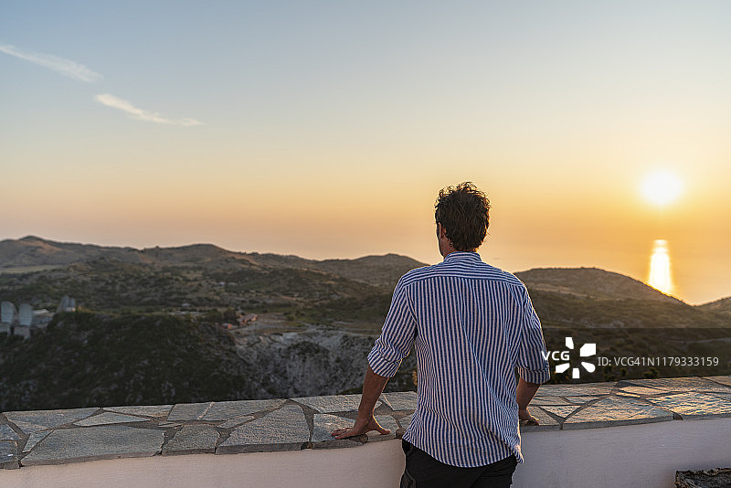 男子在希腊莱夫卡达先知以利亚教堂欣赏日落景观图片素材
