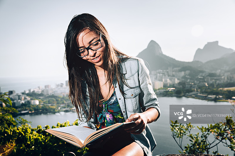 年轻的巴西女子在里约热内卢户外读书图片素材
