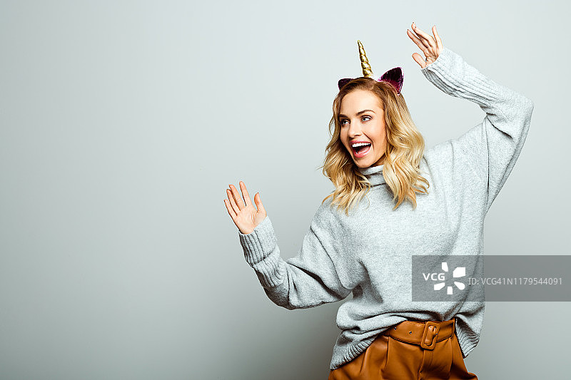 戴独角兽发箍跳舞的美丽女人图片素材