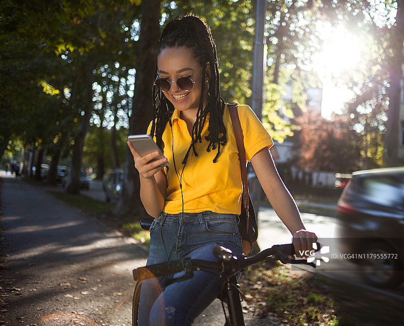 女孩骑自行车发短信图片素材