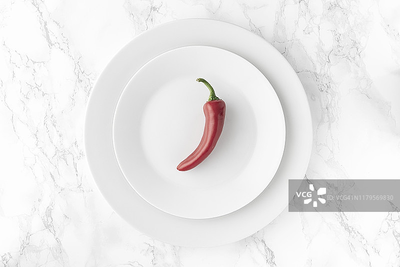 白色盘子里的红辣椒：明亮背景的极简主义图片素材