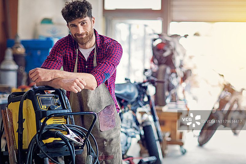 在定制摩托车库工作的男子肖像图片素材