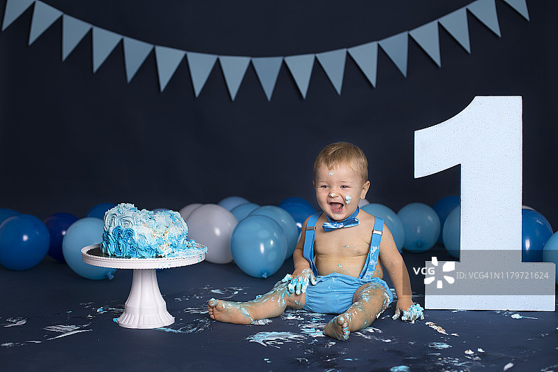 男婴在生日派对上玩蛋糕图片素材