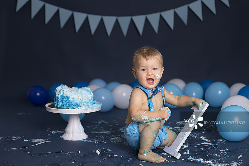 男婴在生日派对上玩蛋糕图片素材