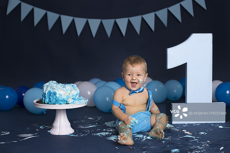 男婴在生日派对上玩蛋糕图片素材