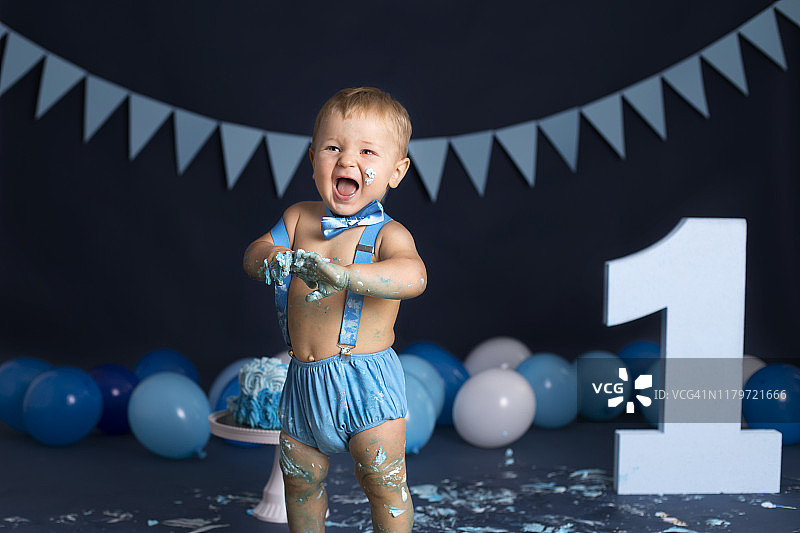 男婴在生日派对上玩蛋糕图片素材