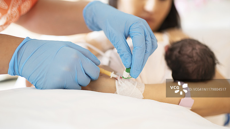 护士戴着蓝色手套为病人插导管图片素材