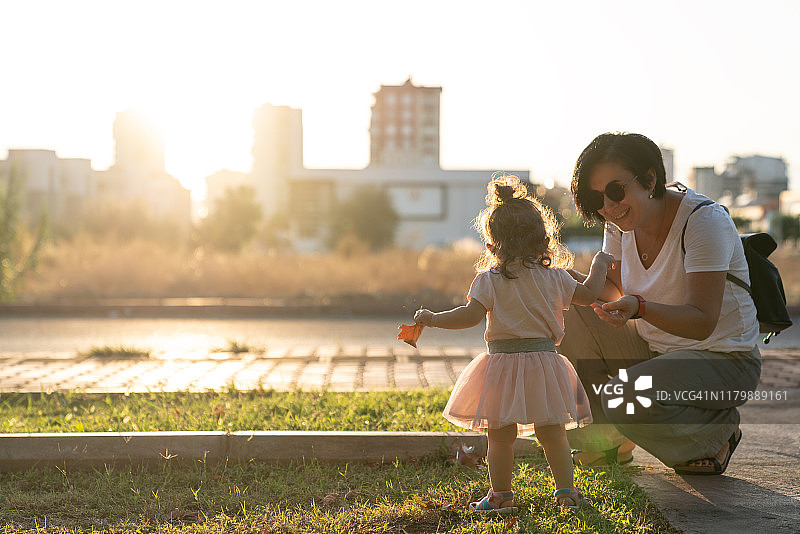 日落时分迈出第一步的幼儿女婴图片素材
