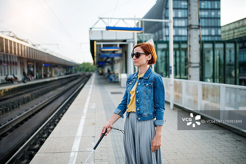 盲人女人持导盲杖站在城市户外图片素材