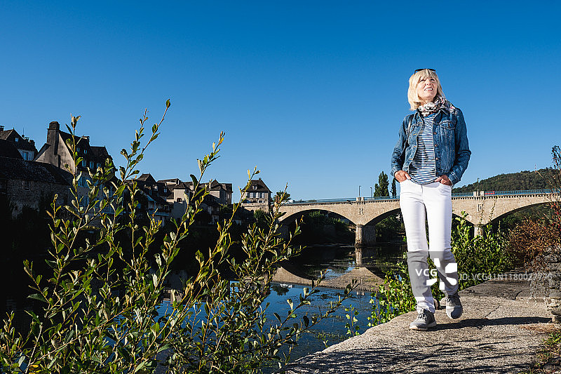女子在法国阿尔让塔河边漫步图片素材
