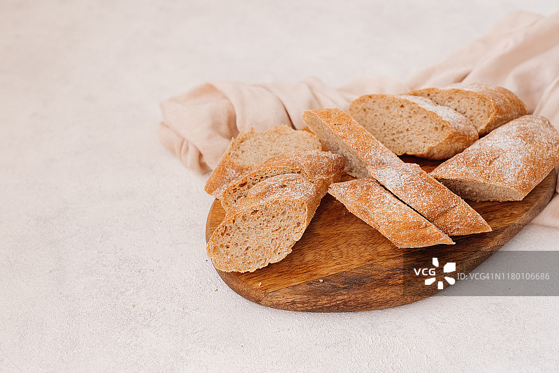 手工切片吐司面包，配黄油和糖，置于木制砧板上。灰色水泥背景上的简约早餐，顶视图图片素材