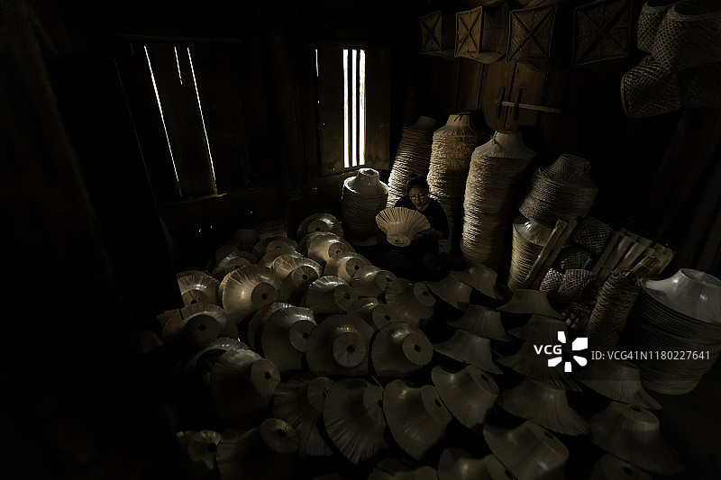 老年妇女在田间手工编织泰国桑诺篮图片素材