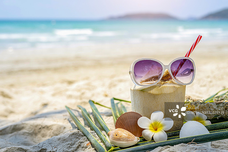 热带海滩上的新鲜椰汁和太阳镜照片图片素材