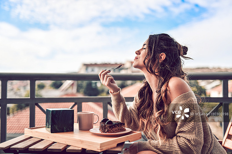 美女享用蛋糕、咖啡，享受宁静的早晨图片素材