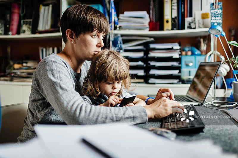 母亲抱着女儿在电脑上打字图片素材