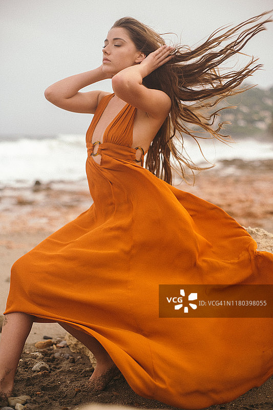 穿着连衣裙坐在岩石上的女孩图片素材