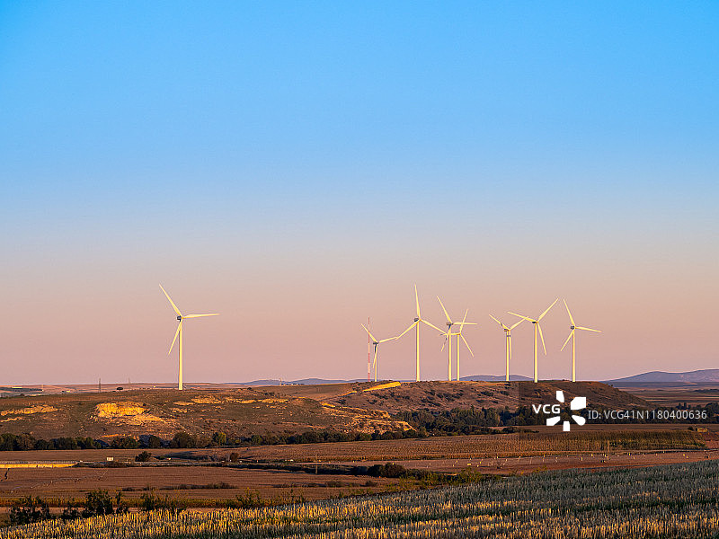 日落时分，晴空下的风力涡轮机图片素材