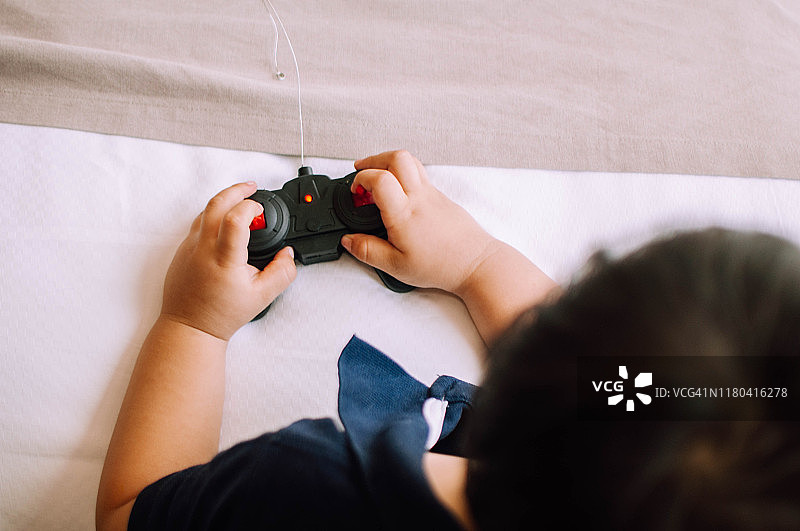 一名男童在卧室里玩遥控汽车图片素材