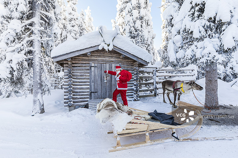 手持圣诞礼物和驯鹿的圣诞老人，芬兰拉普兰图片素材