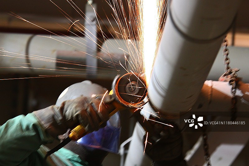 工人用圆锯切割高架管道图片素材