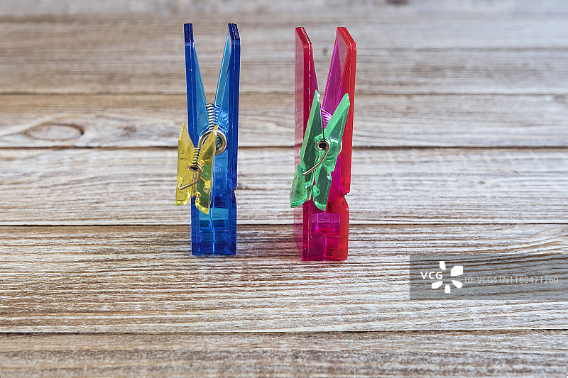 木质背景上代表一家两孩的彩色晾衣夹图片素材