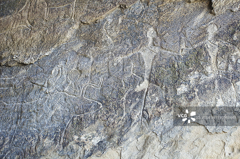科布斯坦岩画保护区洞穴壁上的岩画：原牛和两个史前人类图片素材
