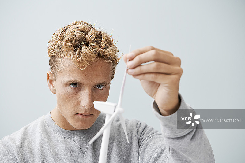 研究风力涡轮机模型的年轻男子图片素材