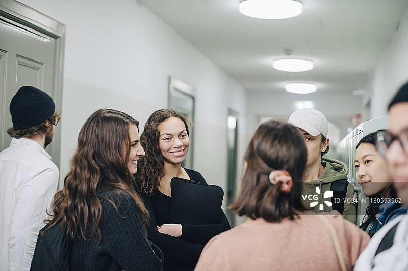 站在走廊里交谈的高中生图片素材